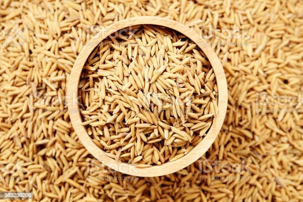 Paddy seeds in wooden bowl on white background